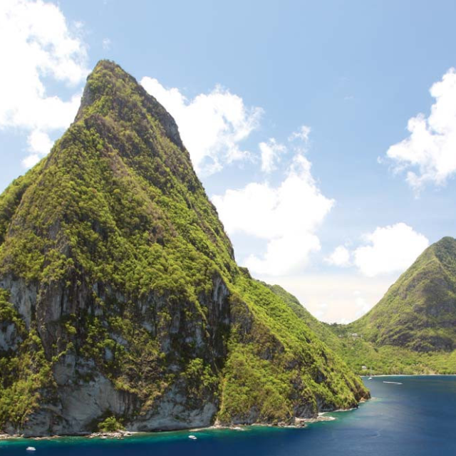 a body of water with Pitons in the background